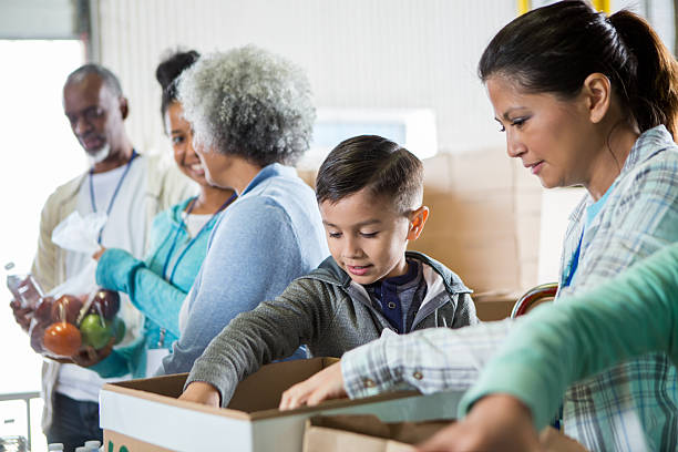 istock Multigenerational group volunteers sort and pack items for distribution, fostering togetherness. 2246234897