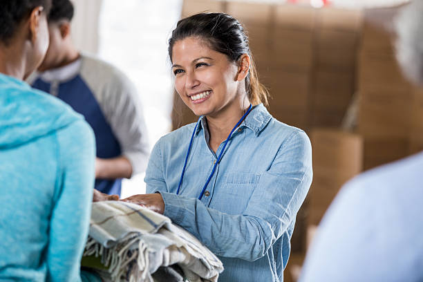 istock Volunteers happily collaborate sorting donations indoors in a bright room. 2246234925