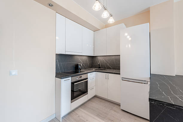 istock Modern Home Compact Kitchen with Sleek White Cabinets and Black Countertops 2246235485