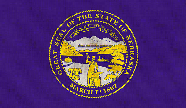 Flag of American state Nebraska on fabric surface. Nebraska state flag on textured background. Colored Nebraska flag on fabric surface. Official American state symbol