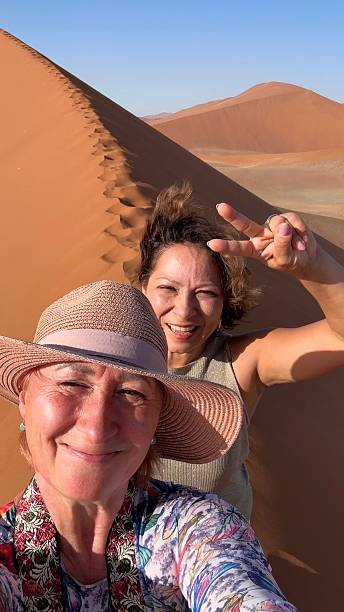 istock Two women take a selfie at Sand Dune 45, Namibia, Africa. 2246237643