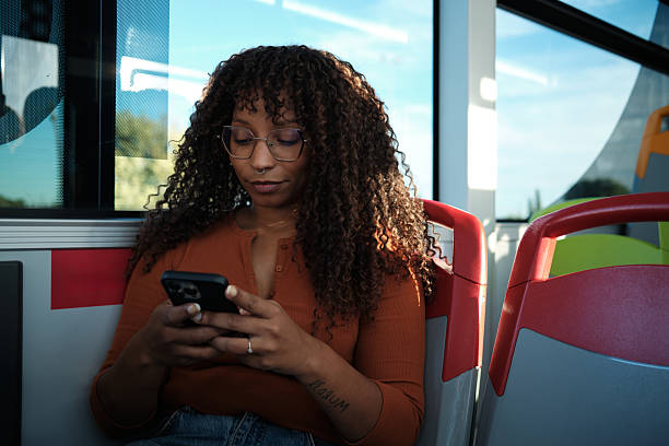 istock Young woman commuting on bus using mobile phone 2246237676