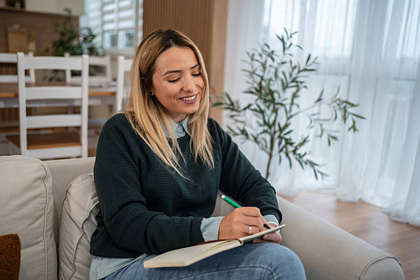 istock Woman writing in journal planning daily routine at home 2246242482