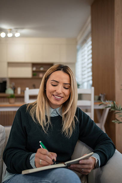 istock Woman writing in journal planning daily routine at home 2246242527