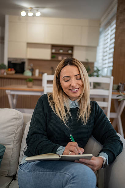 istock Woman writing in journal feeling happy and relaxed 2246242528
