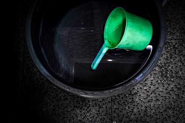 A plastic basin or tub filled with water and a dipper