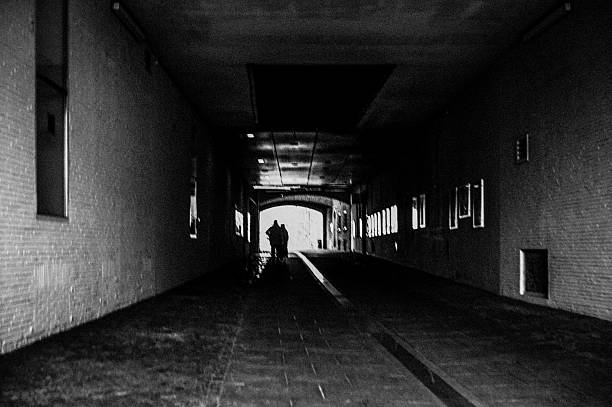istock Abstract silhouette of two people backlit by a passageway 2246244769