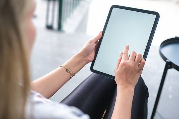 istock Woman hand working on blank white screen digital tablet in coffee shop. 2246245563