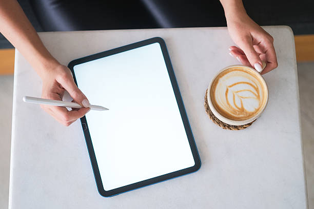 Woman hand working on blank white screen digital tablet with coffee cup in coffee shop.