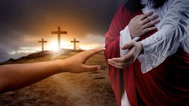 istock Jesus Christ hand offering a helping hand with a Christian cross on dark dramatic sky background. Concept of Christianity, religious, faith, Jesus, or belief 2246246897