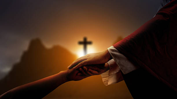 istock Jesus Christ hand offering a helping hand with a Christian cross on dark dramatic sky background. Concept of Christianity, religious, faith, Jesus, or belief 2246246908