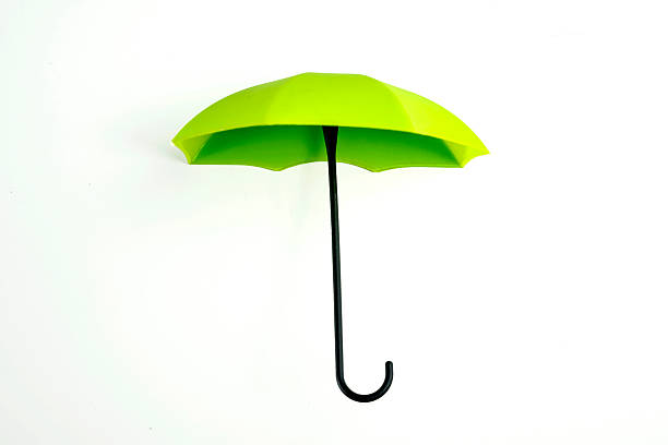 istock Closeup view of a green umbrella with a black handle on a white background 2246246986