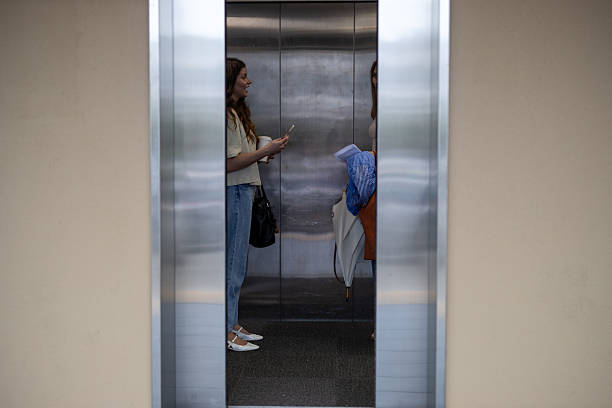 istock Woman Greeting Colleague in Elevator at Work or University 2246246987