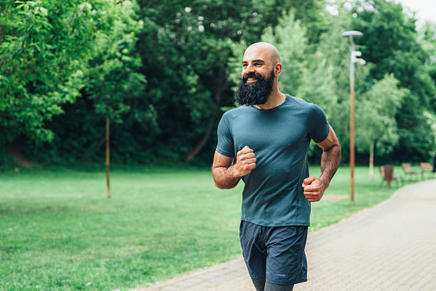 istock Smiling man jogging outdoors in the park. 2246247187