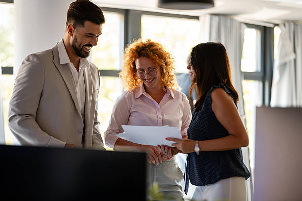 istock Smiling business colleagues discussing documents in office 2246248444