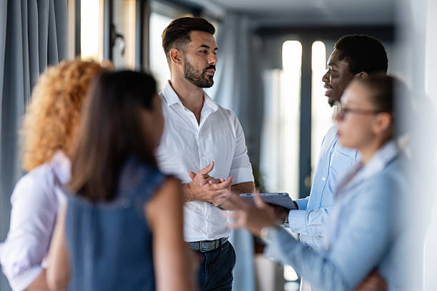 istock Business professionals networking and discussing ideas in modern office hallway 2246248807