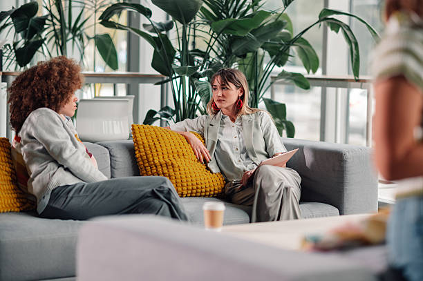 istock Women colleagues discussing work problems in modern office lounge 2246251045