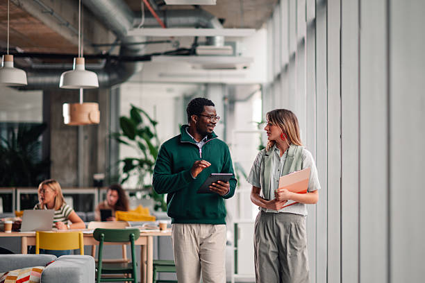 istock Diverse coworkers walking and collaborating with tablet in modern office 2246251746