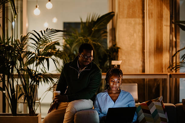 istock Colleagues collaborating on laptop late at night in modern office 2246253376