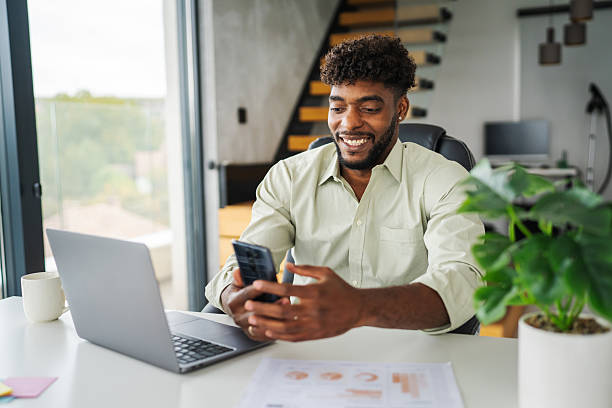 istock Black man holding smart phone making video call at home 2246253604