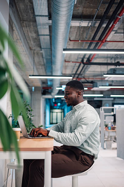 istock Young adult man working laptop modern office architecture 2246253635