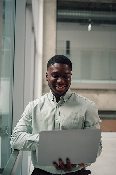 istock Young black businessman using laptop, smiling in office 2246253636
