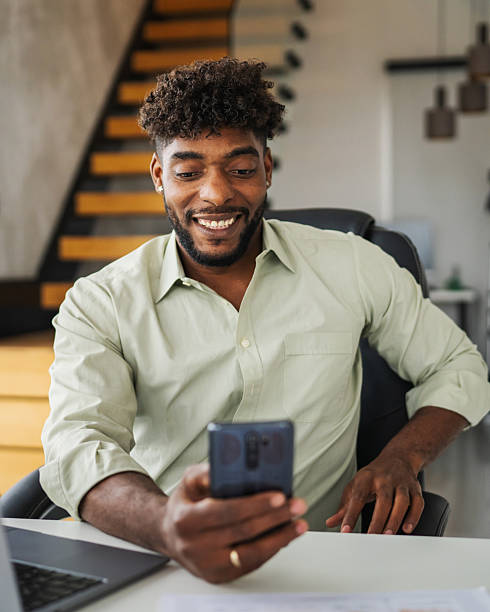 istock Black man holding smart phone making video call at home 2246253689