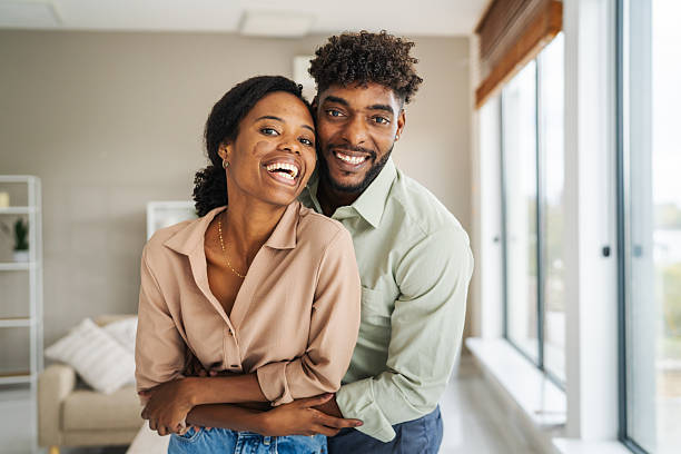 istock Happy black couple embracing at home and smiling 2246253718