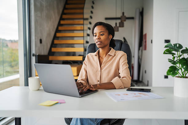 istock Black woman working on laptop at home office 2246253778