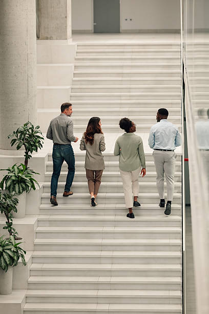istock Business colleagues walking up modern office stairs 2246254197