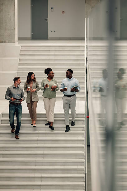 istock Diverse business people walking downstairs discussing work 2246254218