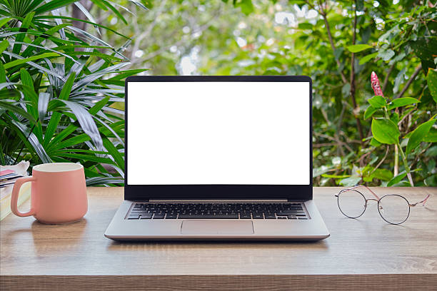 istock Computer laptop on the wood table, nature  background. 2246254536
