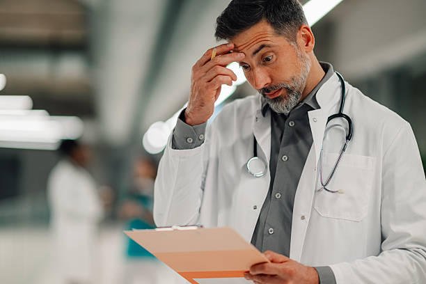 istock Concerned doctor reading medical report on clipboard 2246256454