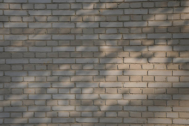 istock Close-up view of a weathered brick wall with shadow patterns 2246256877