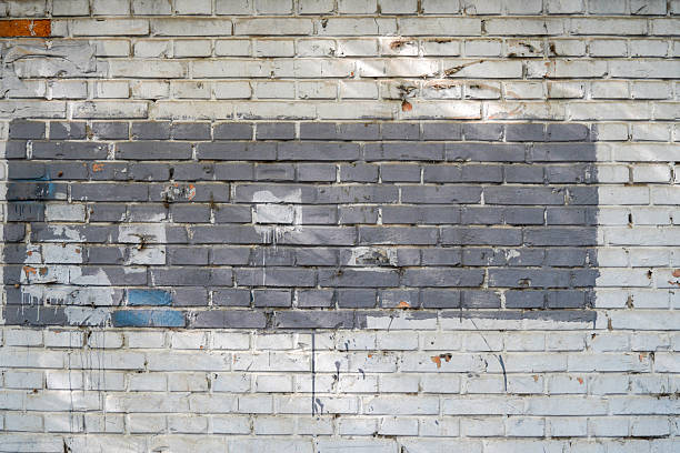 istock Old brick wall with faded painted area showing urban art element 2246258298