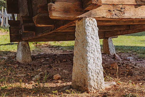 Rustic old wooden building or granary resting on rough stone pillars, lifting the structure from the ground