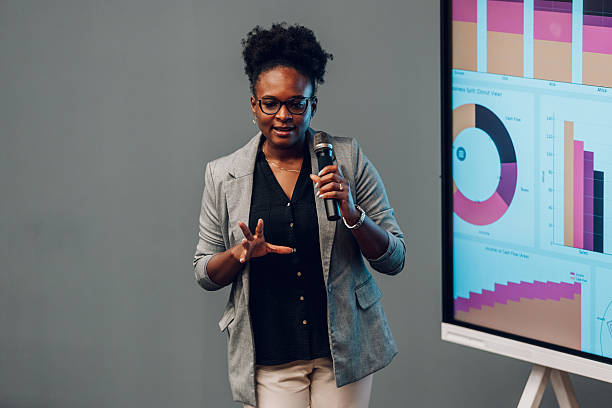 istock Businesswoman giving presentation with data charts on screen 2246260579