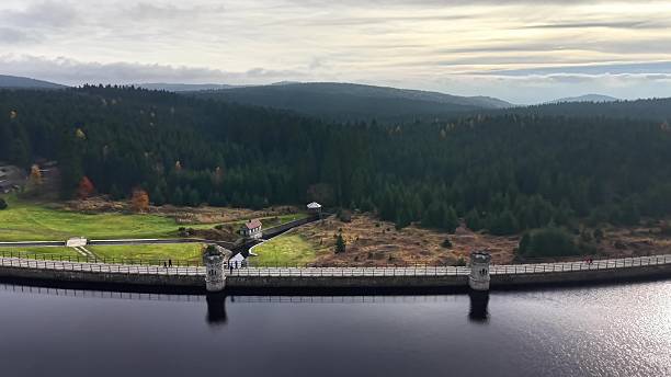 aerial dam and reservoir with concrete spillway and reflective water, engineering structure set