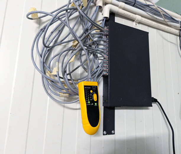 istock Checking RJ 45 cable network connections using a LAN tester, industrial IT support equipment 2246262371