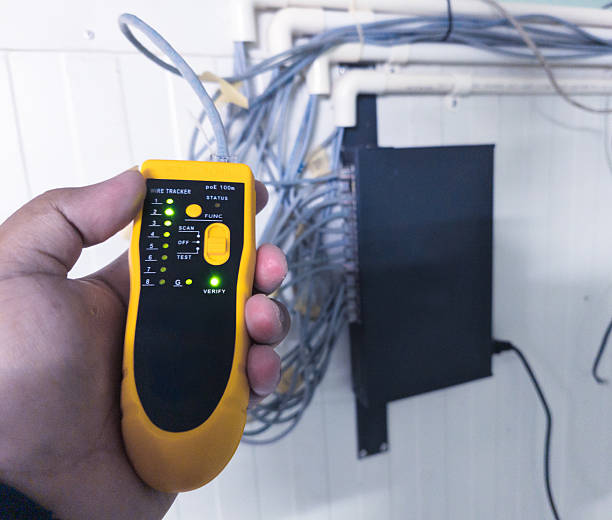 istock Checking RJ 45 cable network connections using a LAN tester, industrial IT support equipment 2246262374