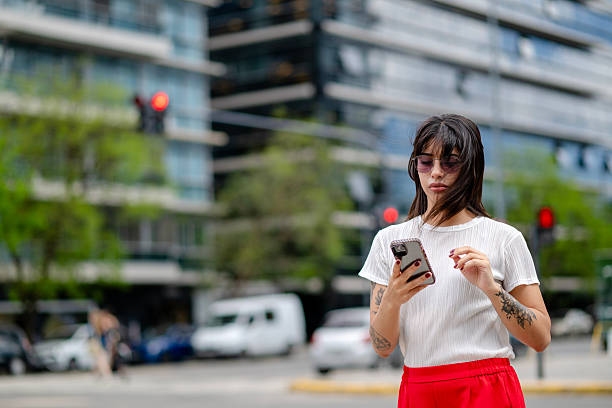 beautiful young executive using her phone on the street