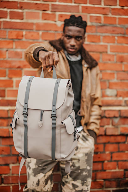 istock Young man enjoys urban life in Berlin while showcasing his stylish backpack against a brick wall backdrop 2246267318