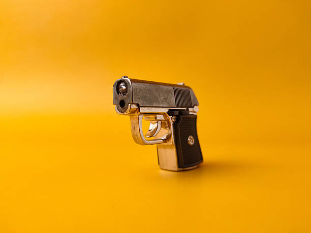 istock A small handgun is on a yellow background 2246267556