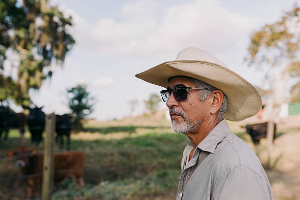Portrait of adult man in cowboy hat and shirt against abandoned building