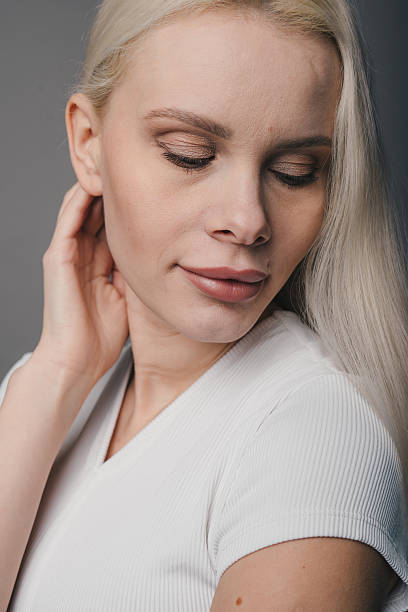 istock sunkissed woman with smooth skin examines herself thoughtfully in softly lit studio environment 2246281324