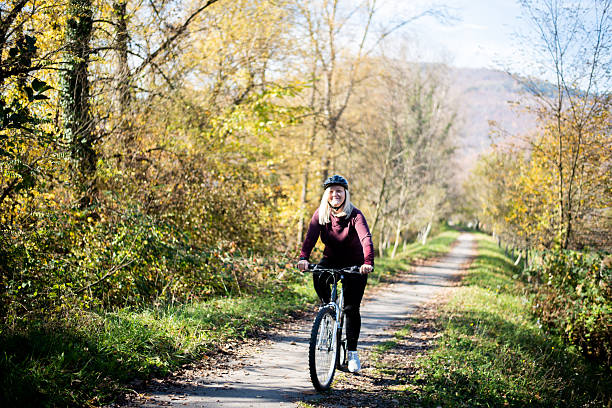Smiling senior woman having fun riding bicycle in the park