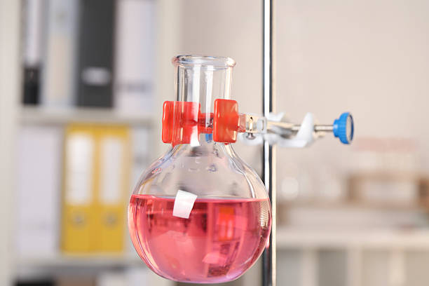 Laboratory analysis. Glass flask with pink liquid on stand indoors, closeup
