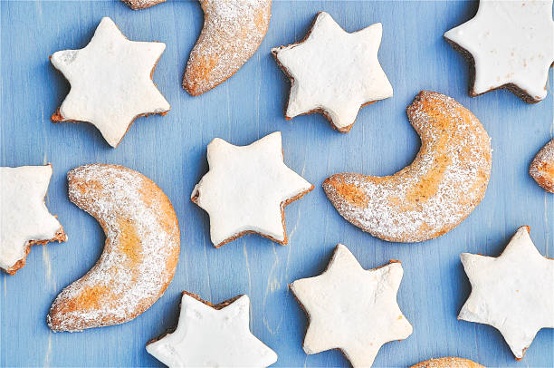 Cozy and festive flat lay of star and crescent Christmas cookies on a wooden blue background, evoking warmth, nostalgia and holiday joy. Full frame - Christmas, holiday