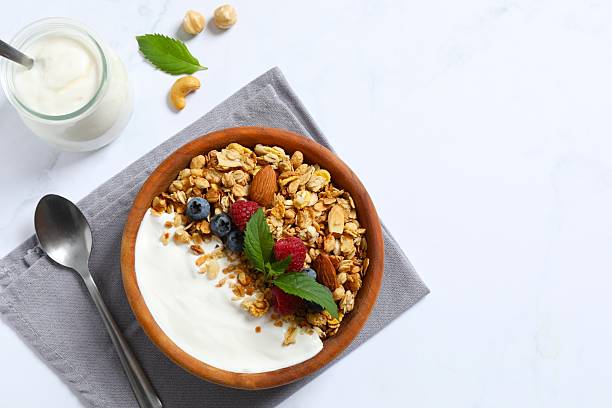 istock Tasty granola with berries and yogurt on a light background 2246299905