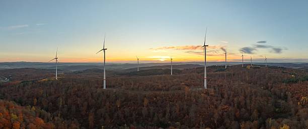 istock Wind turbines at sunset over a forested landscape. 2246300051